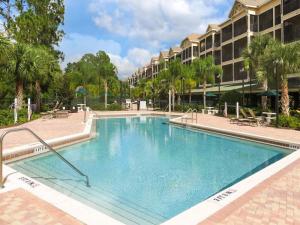 una piscina en un complejo con árboles y un edificio en 3BR Condo - Games Hot Tub Sauna - Near Disney en Orlando