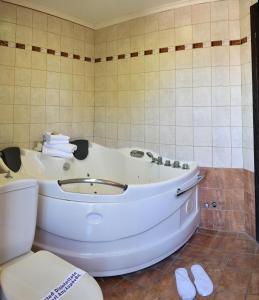 a white tub in a bathroom with a toilet at Four Seasons Hotel in Trílofon