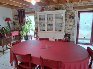 ein Esszimmer mit einem roten Tisch und Stühlen in der Unterkunft Stone House in Lilia near Ile Vierge Lighthouse in Plouguerneau