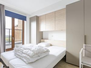 ein Schlafzimmer mit einem weißen Bett und einem Fenster in der Unterkunft Prestige I 3 bedrooms on floor 10 in Middelkerke