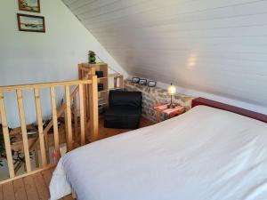 ein Schlafzimmer mit einem weißen Bett und einem Stuhl in der Unterkunft Stone House in Lilia near Ile Vierge Lighthouse in Plouguerneau