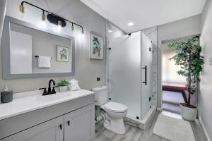 biała łazienka z toaletą i prysznicem w obiekcie MODERN KING BED HOME CLOSE TO THE BEACH AND STORES. QUIET NEIGHBORHOOD AND PET FRIENDLY! w mieście Jensen Beach