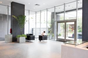 a person sitting in a chair in a lobby at Asunción Rent Suites Santa Teresa in Asuncion