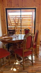 een eetkamer met een houten tafel en stoelen bij Acogedora Cabaña in Cartagena