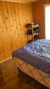 een slaapkamer met een bed en een houten wand bij Acogedora Cabaña in Cartagena +13 foto's