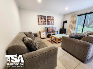 ein Wohnzimmer mit 2 Sofas und einem TV in der Unterkunft Pagano 4 in Thredbo