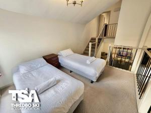 2 Betten in einem Zimmer mit einer Treppe in der Unterkunft Pagano 4 in Thredbo