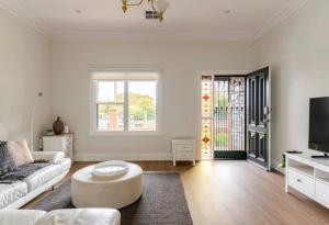 ein weißes Wohnzimmer mit einer Couch und einem Tisch in der Unterkunft Stylish Villa in Nailsworth By Host Solutions in Broadview