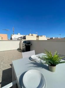 a white table with plates and a plant on a roof at UIM Mediterraneo ATICO Cendoya Wifi in Puerto de Sagunto