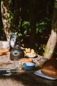 uma mesa com pão e uma panela e comida nela em Pousada encanto da cachoeira em Aguas Mornas