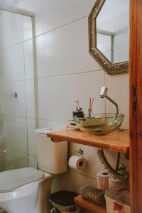 ein Badezimmer mit einem Waschbecken, einem WC und einem Spiegel in der Unterkunft Pousada encanto da cachoeira in Aguas Mornas