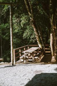 una mesa de picnic de madera sentada junto a una valla en Pousada encanto da cachoeira, en Aguas Mornas