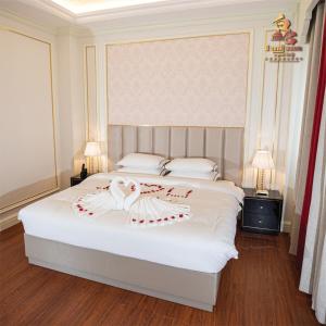 THE PREMIER PALACE HOTEL AND SPA في بنوم بنه: غرفة نوم عليها سرير وبجعة