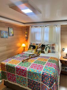 a bedroom with a large bed with a colorful quilt at Lambú Ecoturismo in Cidade Ocidental