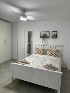 een witte slaapkamer met een groot wit bed met kussens bij UIM Mediterraneo ATICO Cendoya Wifi in Puerto de Sagunto