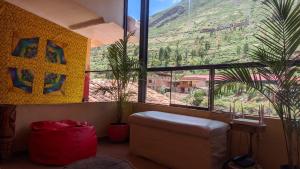 a living room with a couch and a large window at Aguaymanto pisac hostel in Pisac