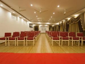 an empty hall with red chairs and a red carpet at MGM Whispering Wind's Yelagiri in Yelagiri