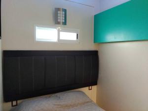 a bedroom with a black headboard and a window at bonito mini depto. equipado Futurista in Atlacomulco de Fabela