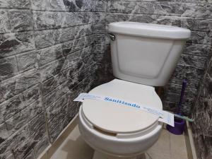 a white toilet in a bathroom with a tape measure on it at bonito mini depto. equipado Futurista in Atlacomulco de Fabela