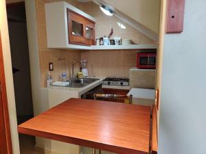 a kitchen with a wooden table and a sink at bonito mini depto. equipado Futurista in Atlacomulco de Fabela