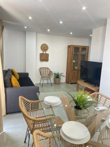 een woonkamer met een tafel en stoelen en een bank bij UIM Mediterraneo ATICO Cendoya Wifi in Puerto de Sagunto