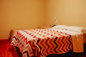 un grande letto con una coperta colorata di HOTEL REALICO a Realicó