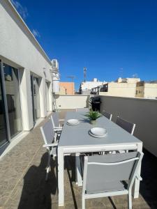 een witte tafel en stoelen op een balkon bij UIM Mediterraneo ATICO Cendoya Wifi in Puerto de Sagunto