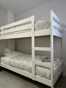 twee witte stapelbedden in een kamer bij UIM Mediterraneo ATICO Cendoya Wifi in Puerto de Sagunto