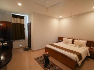 a bedroom with a large bed and a bathroom at MGM Whispering Wind's Yelagiri in Yelagiri