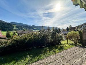 vistas a un patio con arbustos y casas en FEWO Elsa, en Oberstaufen