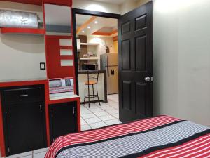 um pequeno quarto com uma cama e uma cozinha em Elegante departamento confortable em Atlacomulco de Fabela