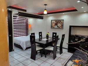 - une salle à manger avec une table, des chaises et un lit dans l'établissement Elegante departamento confortable, à Atlacomulco de Fabela