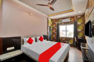 a bedroom with a large bed with red pillows at OYO Flagship Hotel 7 Star in Udaipur