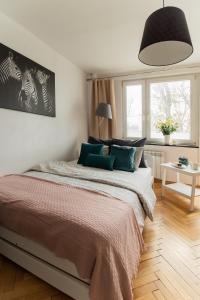 1 dormitorio con 1 cama grande con almohadas verdes en PiotrApartments II, en Varsovia