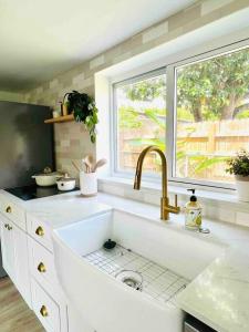 a white kitchen with a sink and a window at La Casita in Miami