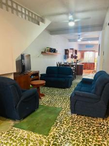ein Wohnzimmer mit blauen Sofas und einem TV in der Unterkunft Casa Mágica in Flores