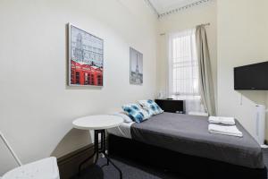 a small bedroom with a bed and a table at Falcon Lodge in Sydney