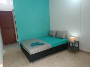 a bed in a room with a blue wall at Tamarindo in Santa Marta