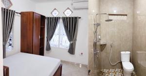a bathroom with a shower and a toilet and a sink at SAMAWA FAMILY House in Banyuwangi +17 photos