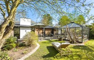 a garden with a greenhouse and a bench in the yard at Stunning Home In Gilleleje With Wifi in Gilleleje