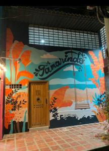 Tamarindo في سانتا مارتا: مبنى به لوحة جدارية ملونة على الحائط