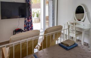 a living room with a tv and a table and chairs at Nice Home In Zemunik Donji With Kitchen in Smrdelje