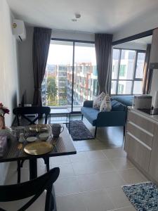 een woonkamer met een bank en een tafel bij Centrio Condominiums Top Floor with Pool and Garden view in Ban Na Khua