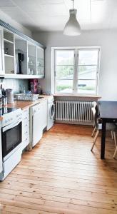 cocina con electrodomésticos blancos y suelo de madera en The Catch, en Køge