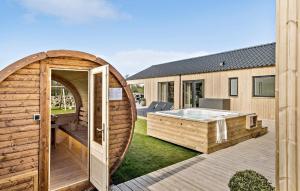 uma casa de madeira com uma banheira de hidromassagem no quintal em Lovely Home In Hadsund With Indoor Swimming Pool em Hadsund