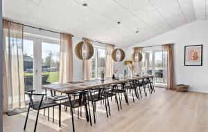 uma sala de jantar com uma mesa longa e cadeiras em Lovely Home In Hadsund With Indoor Swimming Pool em Hadsund