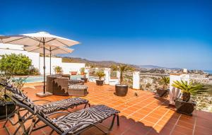 a patio with chairs and an umbrella on a roof at Beautiful Home In Almuñecar With Wifi in Almuñécar +12 photos