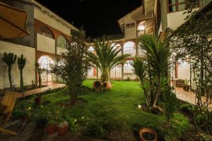 un patio con palmeras y plantas en un edificio en Wilkamayu Hotel, en Sicuani
