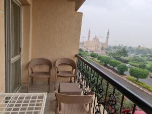 a balcony with chairs and a view of a city at TBK1 apartment in Alrehab city for families only in Burg el-Ḥudûd
