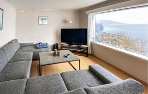 a living room with a couch and a large window at Amazing Home In Strandebarm With House Sea View in Strandebarm